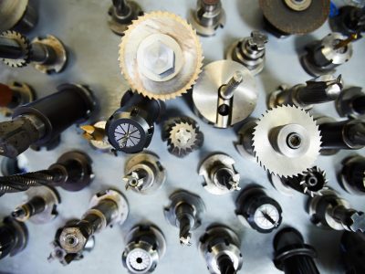 High angle view of metal milling cutters with various bits on steel table